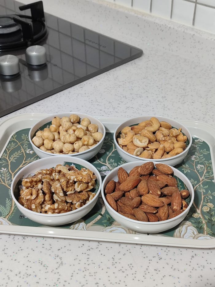 Diverse selection of nuts displayed on a decorative tray in a modern kitchen setting.